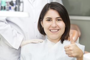 Smiling woman in dental chair: bone grafting